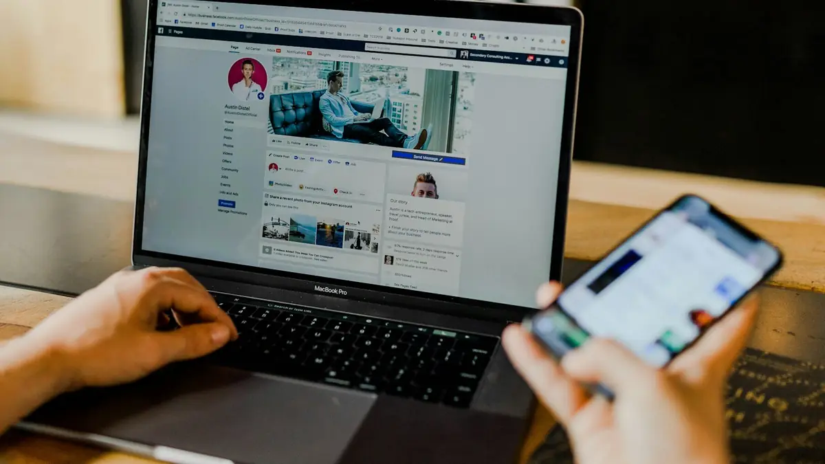 Persona usando un portátil y un teléfono inteligente al mismo tiempo
