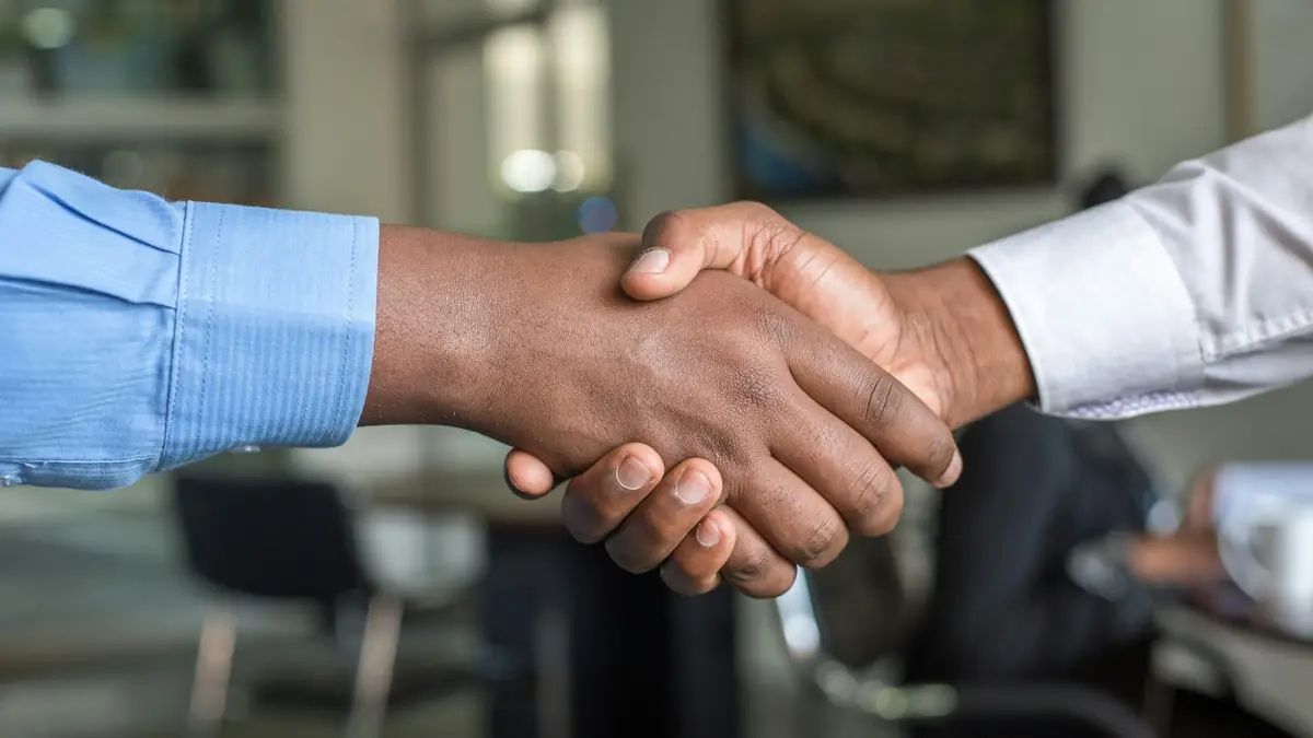 Dos personas dándose la mano para cerrar un acuerdo