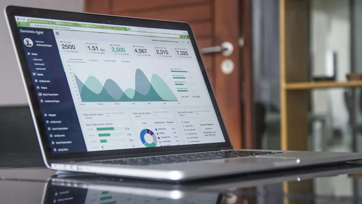 Laptop on a table showing a marketing metrics dashboard