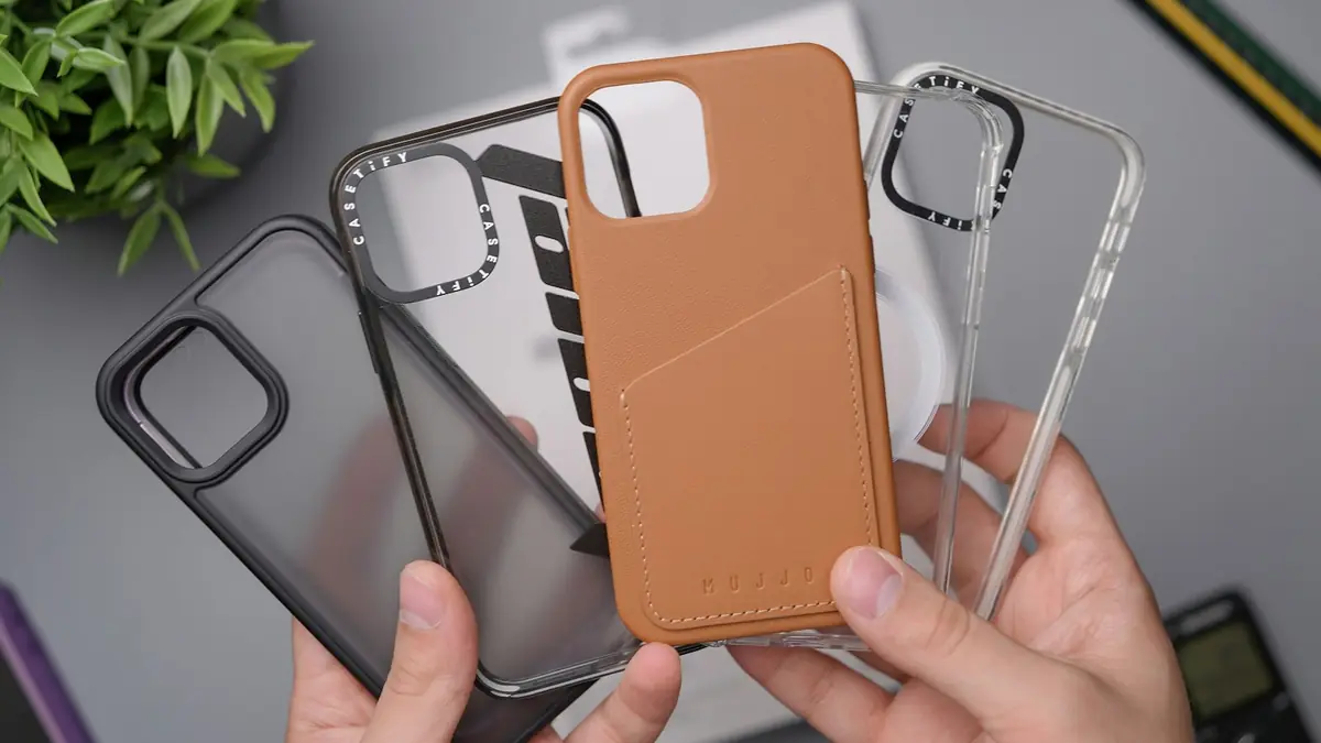 Manos mostrando varias fundas de teléfono de distintos colores
