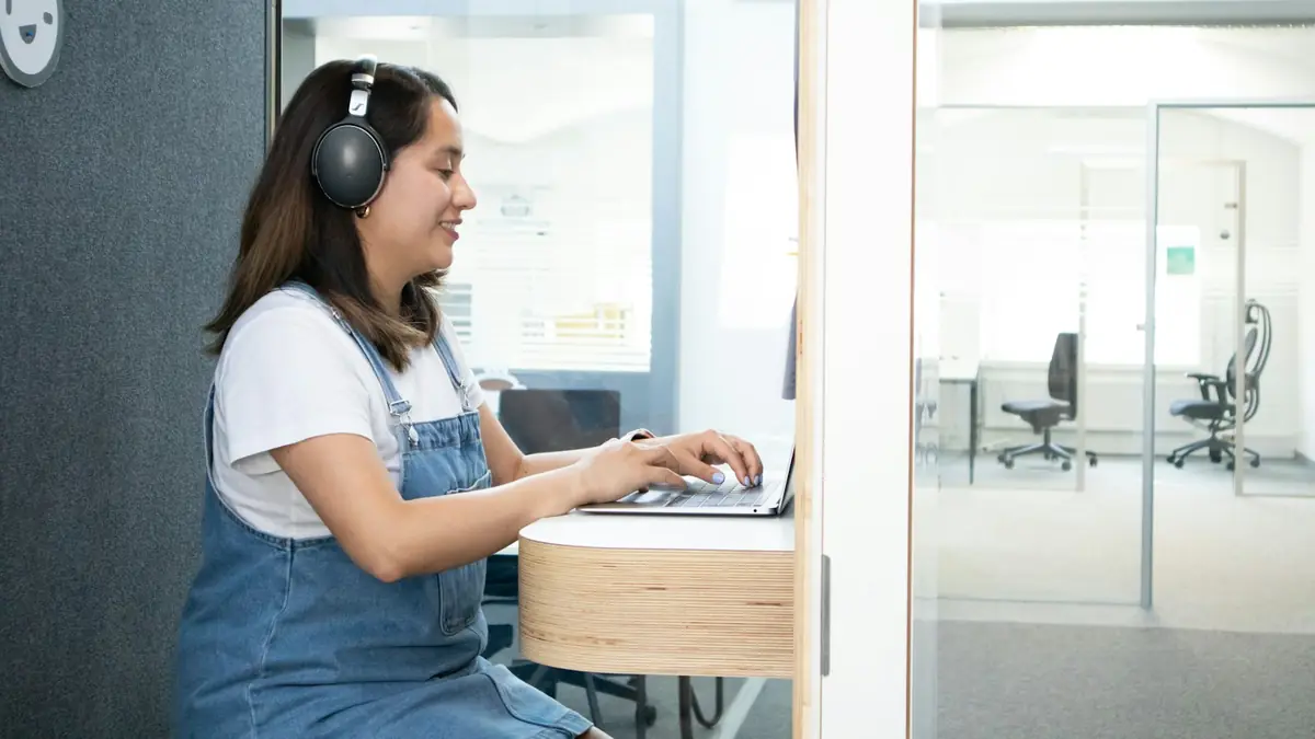 Advisor with headphones serving customers from her laptop
