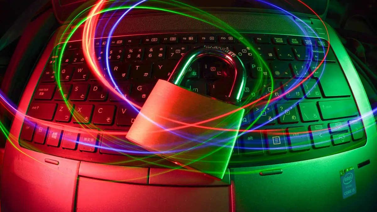 Candado sobre un teclado iluminado por estelas de luz de colores