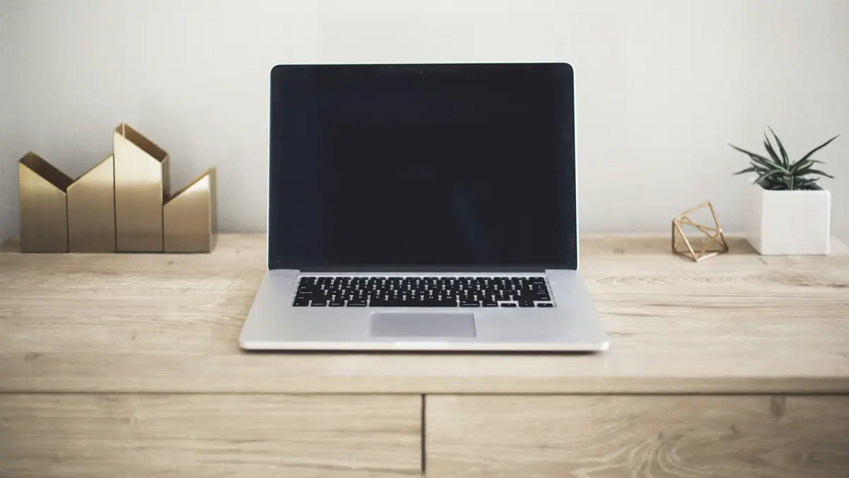 Notebook fechado sobre uma mesa de madeira, pronto para revisar a configuração de um domínio