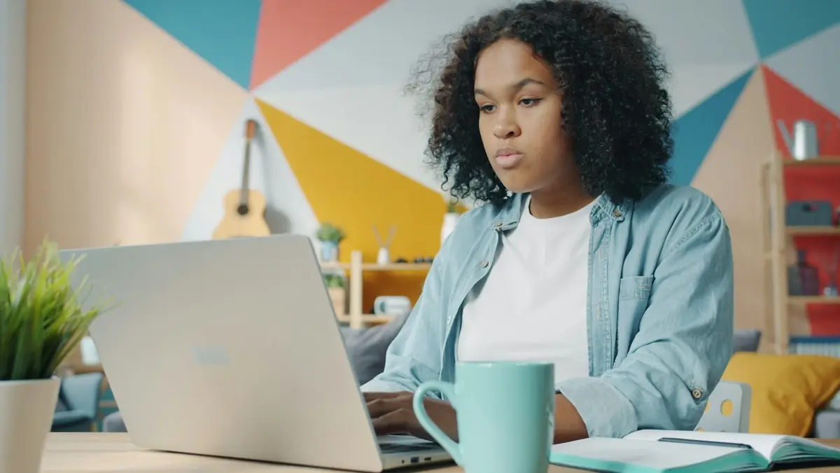 Mujer estudiando en su portátil desde casa