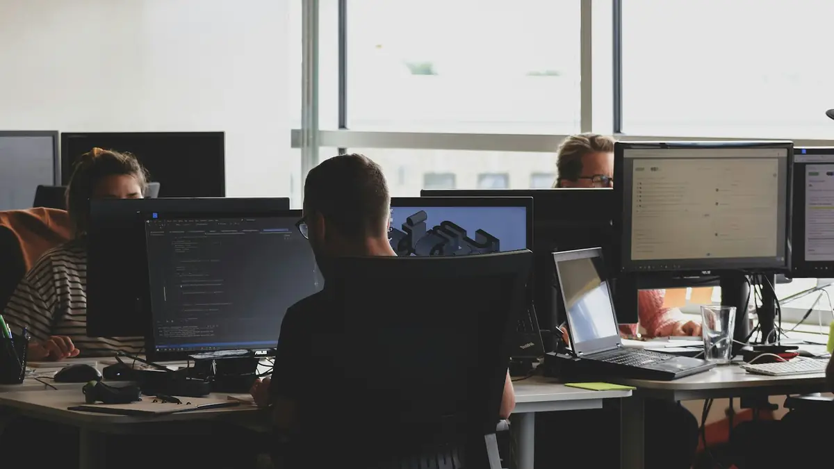 Equipo de ventas trabajando frente a monitores en una oficina