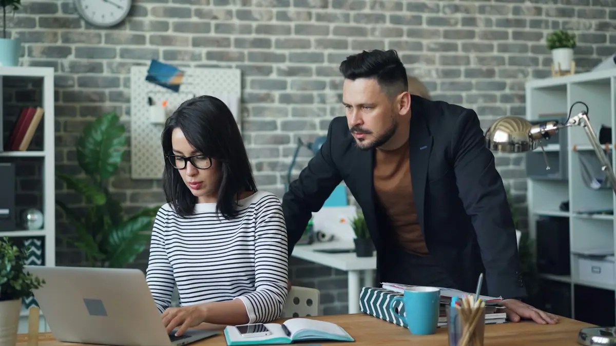 Two colleagues reviewing a laptop together in the office