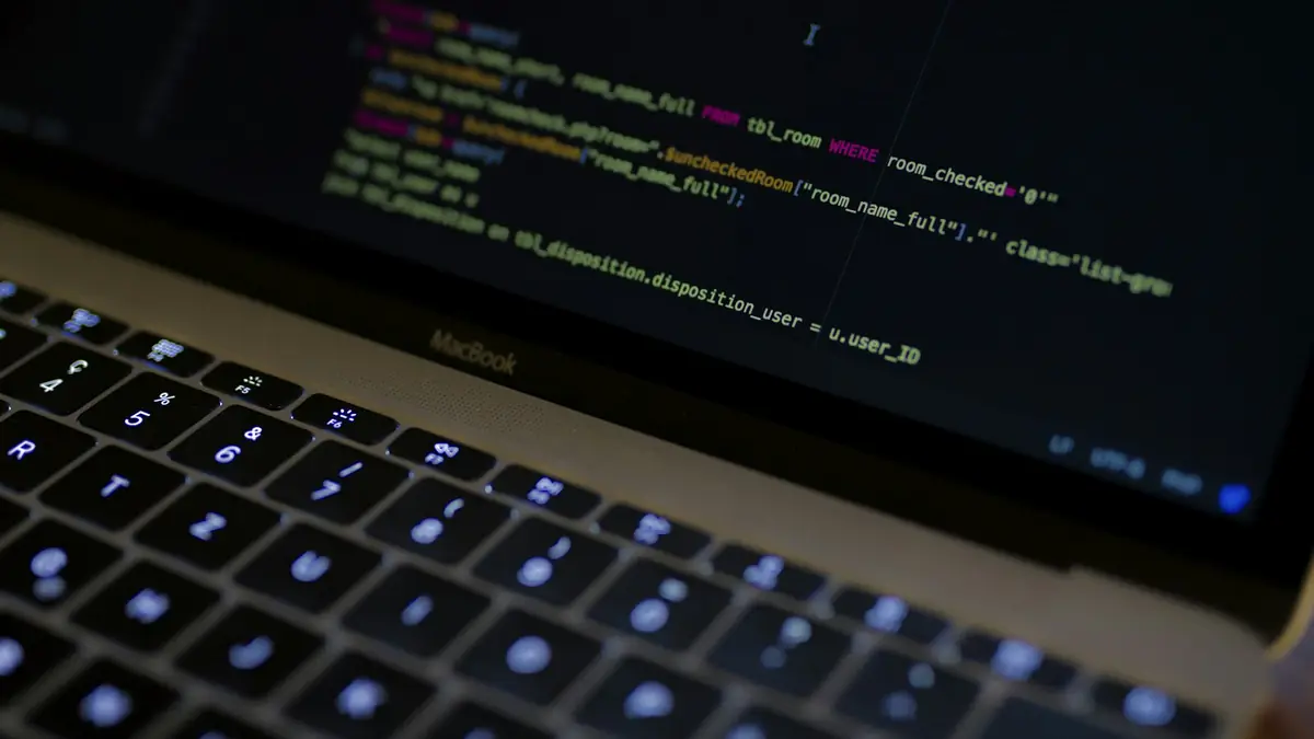 Portátil mostrando código de programación en un ambiente oscuro