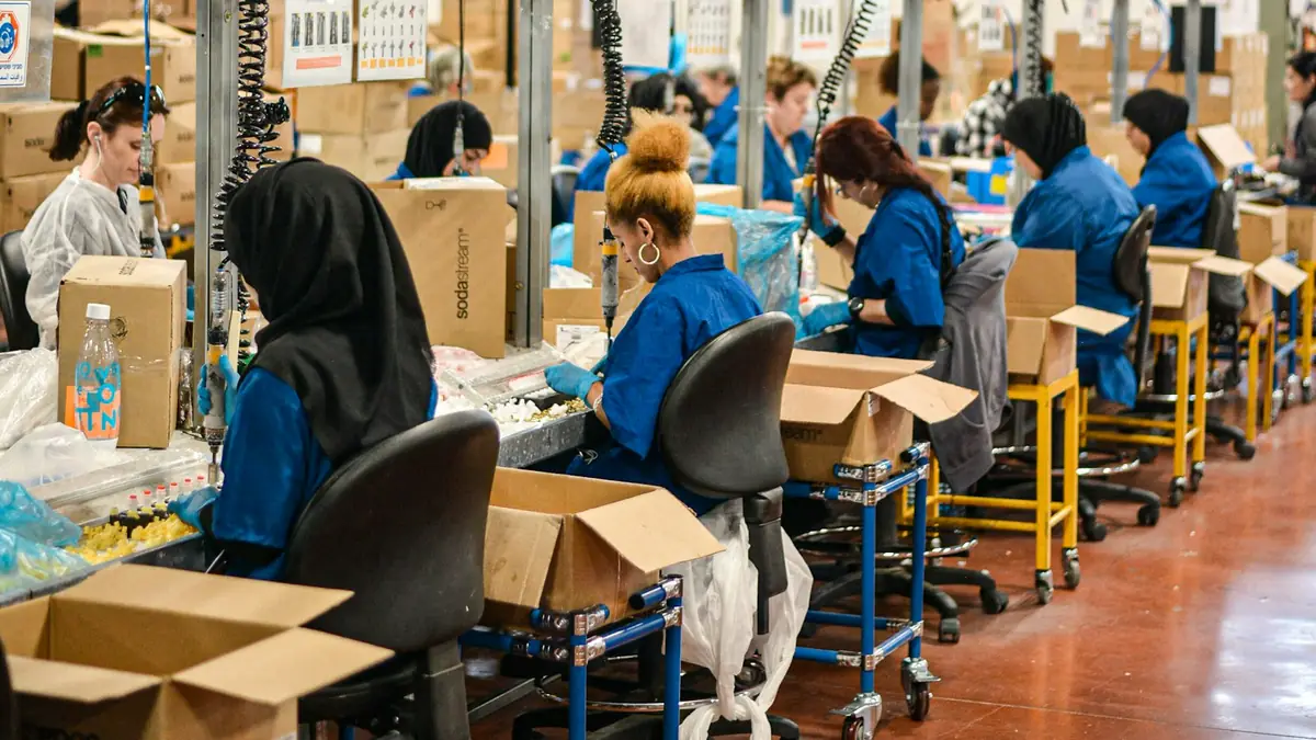 Trabajadores en una línea de montaje dentro de una fábrica