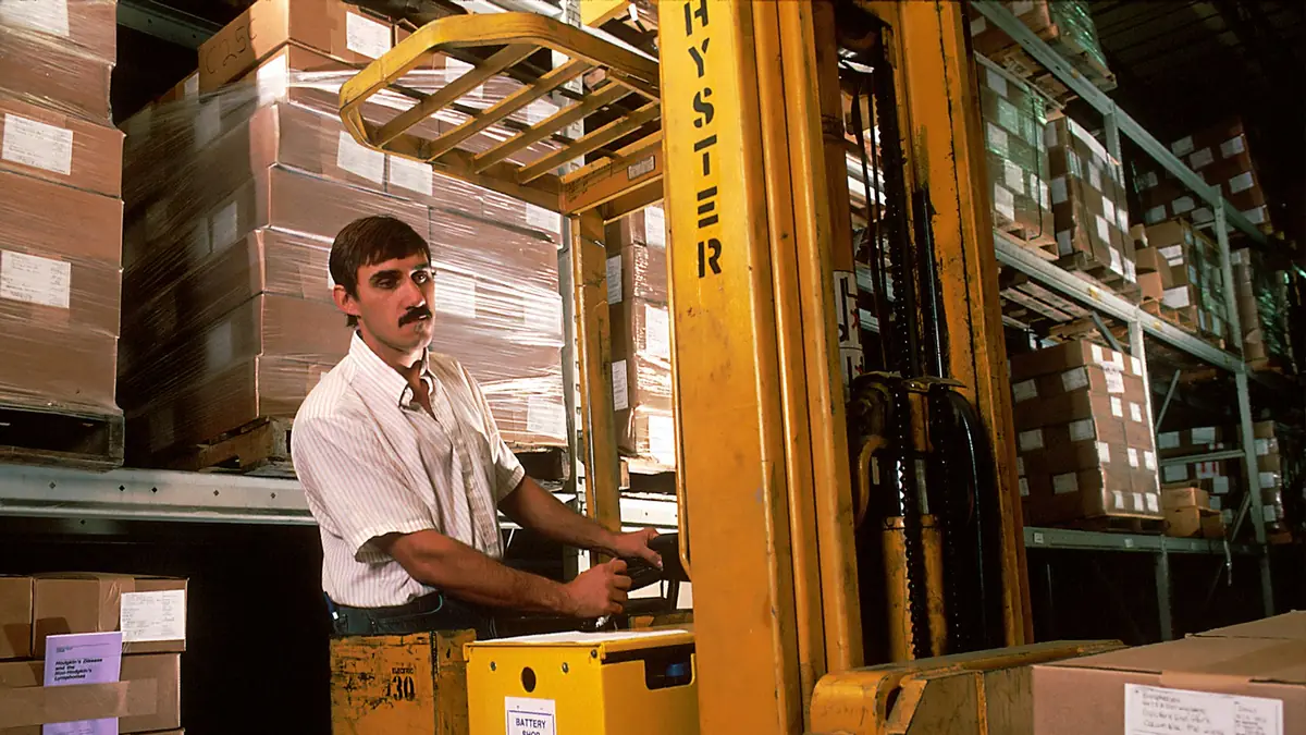 Worker driving a forklift inside a warehouse