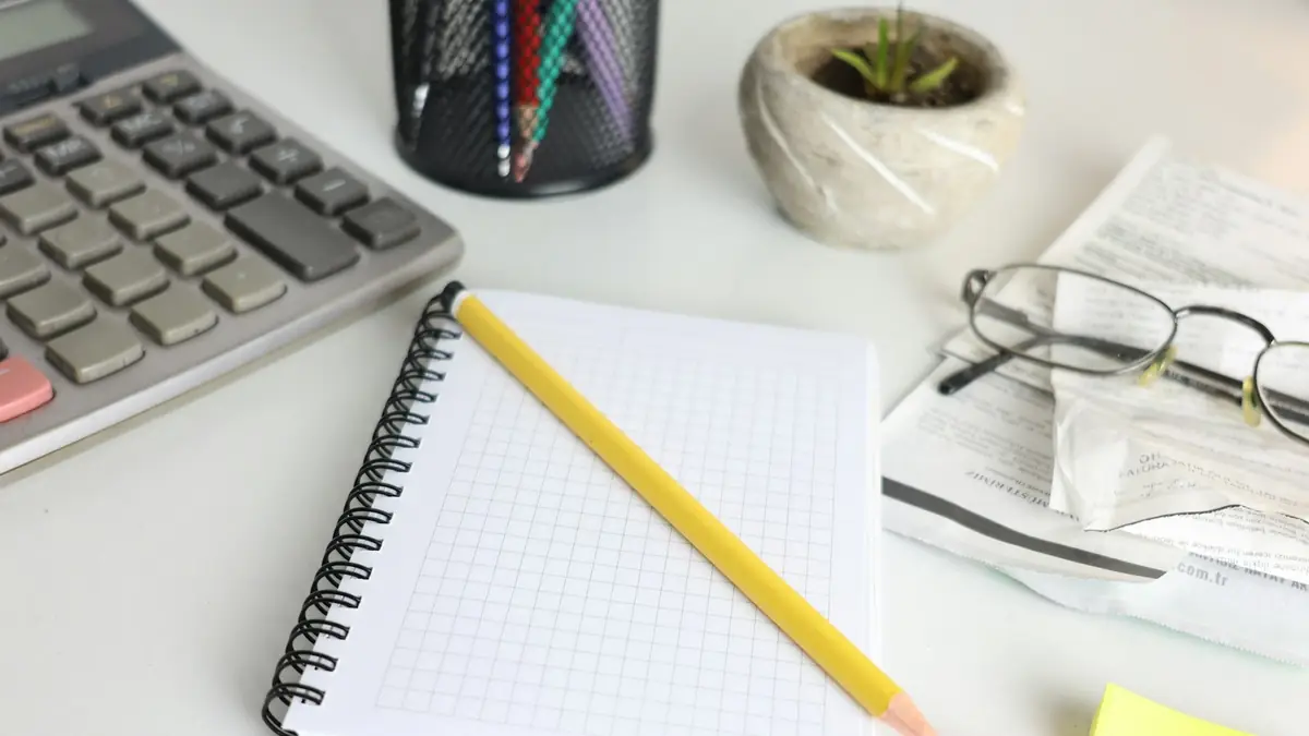 Escritorio con calculadora, cuaderno y papeles de oficina