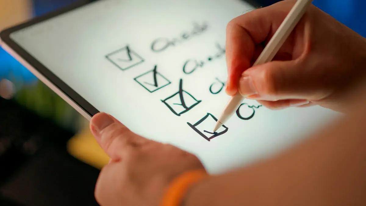 Hand ticking the boxes of a list on a tablet with a digital pen