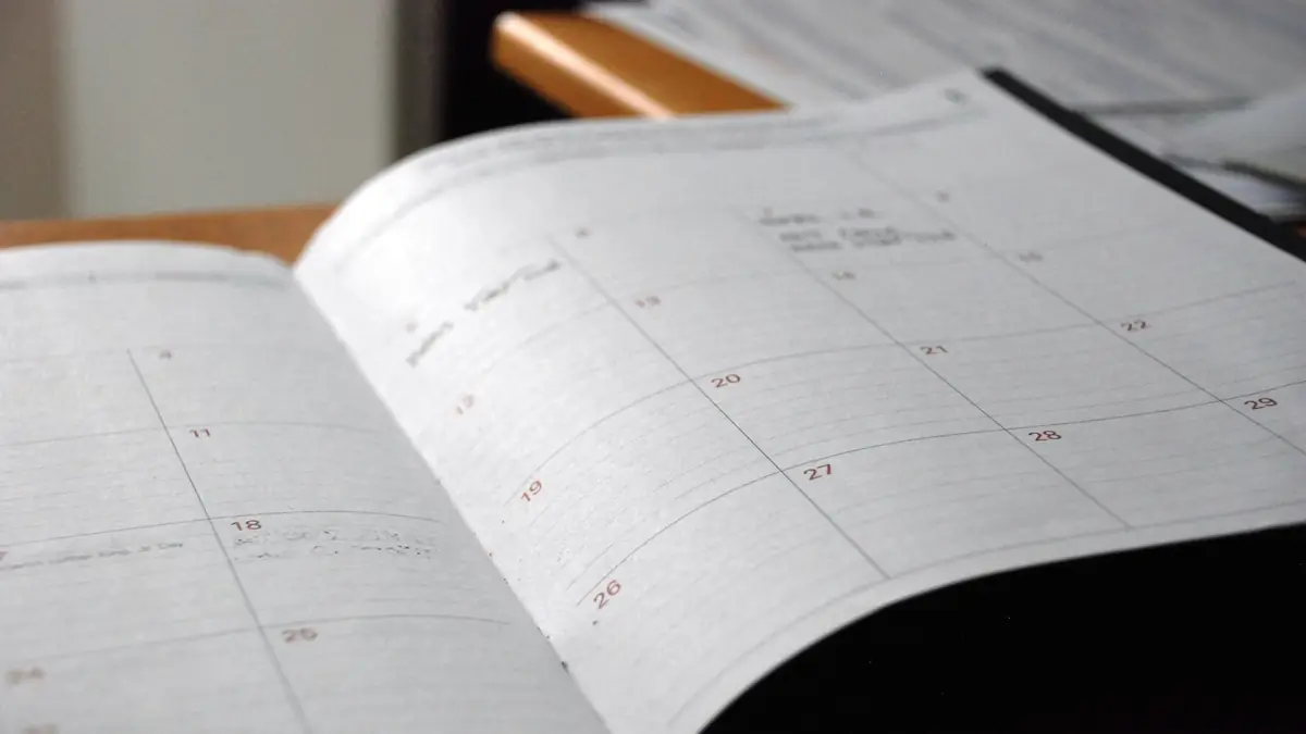 Agenda mensual abierta sobre un escritorio de madera