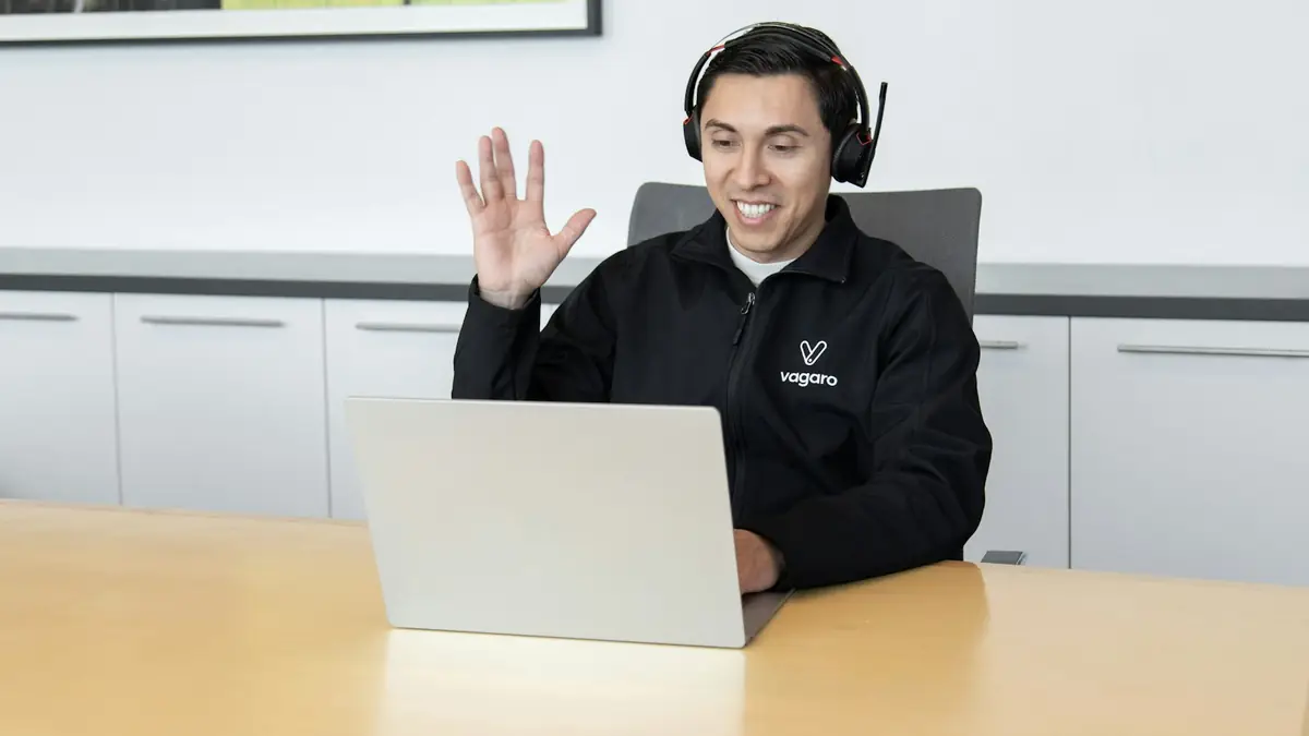 Agente de soporte con auriculares atendiendo desde un portátil