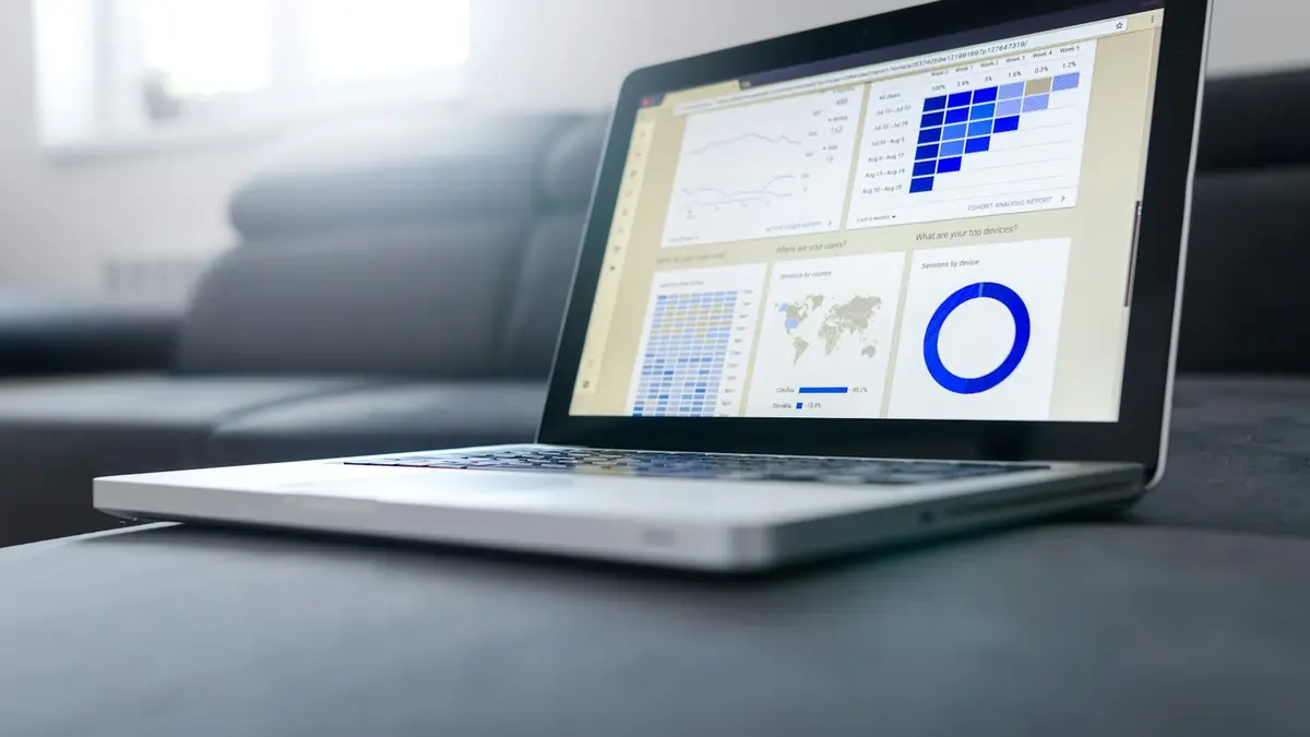 Laptop on a sofa showing data charts of a website