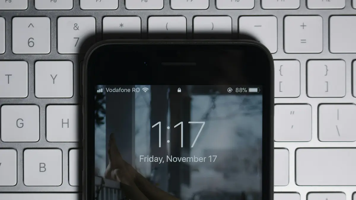 Phone with the lock screen on, resting on a white keyboard
