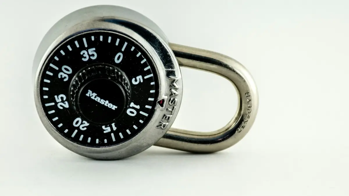 Silver and black combination lock on a white background