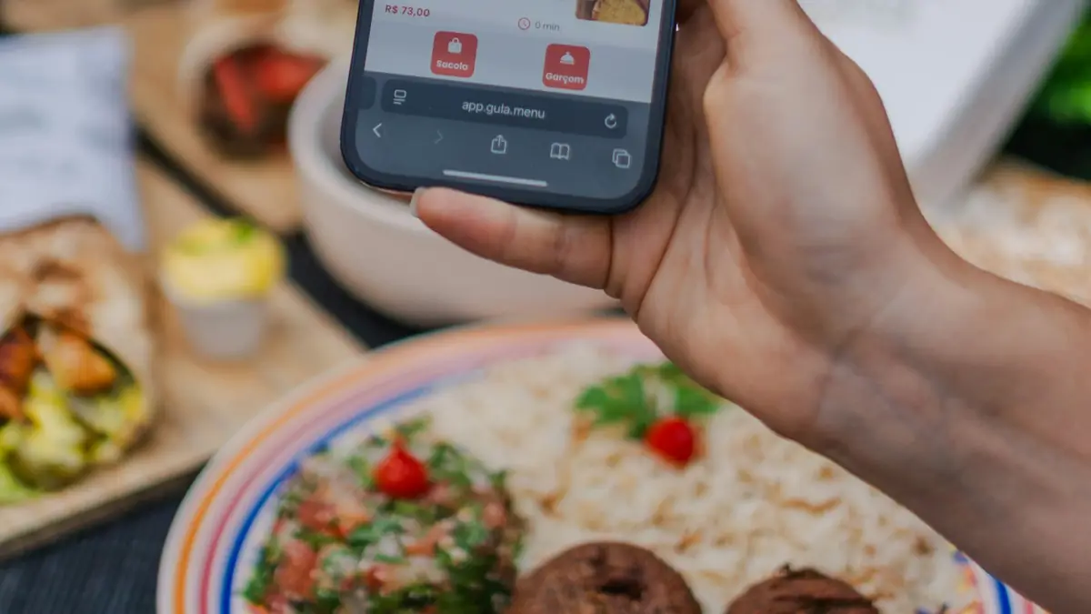 Mano sosteniendo un teléfono con una aplicación de pedidos de comida