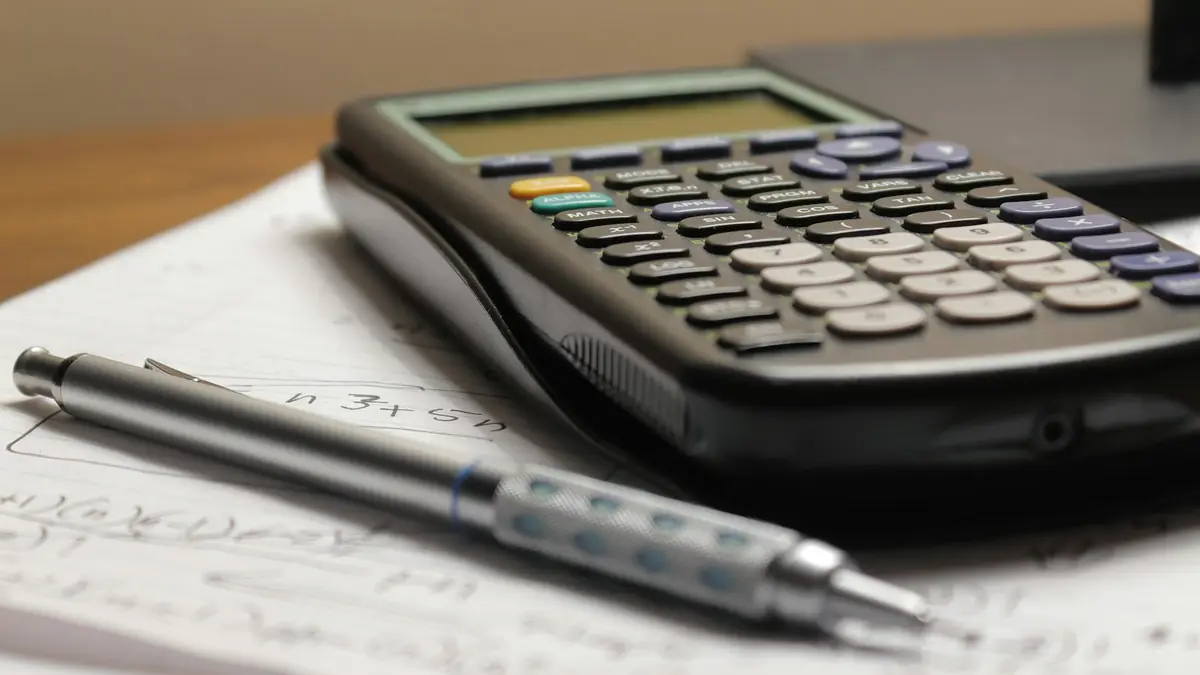 Calculadora y bolígrafo sobre una hoja con cuentas